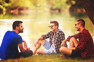 hommes assis au bord de la rivière photo