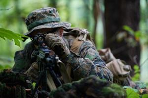 Soldat en action visant l'optique de visée laser de l'arme photo