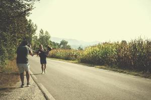 vidéaste enregistrant pendant qu'un couple fait du jogging le long d'une route de campagne photo