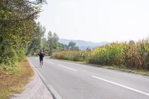 couple heureux faisant du jogging le long d'une route de campagne photo