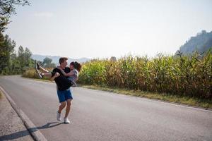couple heureux faisant du jogging le long d'une route de campagne photo