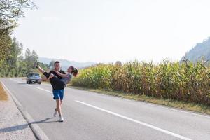 couple heureux faisant du jogging le long d'une route de campagne photo