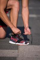 jeune athlète, coureur nouer des lacets dans des chaussures photo