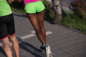 jeune couple multiethnique souriant faisant du jogging dans la ville photo