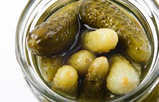 concombres marinés dans un bocal en verre. fond de concombres. photo