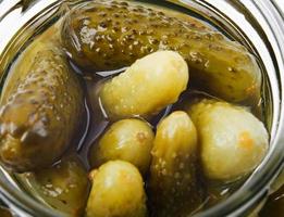 concombres marinés dans un bocal en verre. fond de concombres. photo