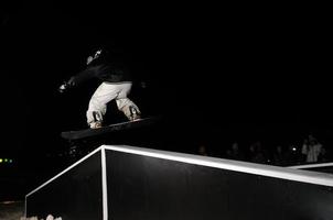 snowboarder freestyle sauter dans l'air la nuit photo