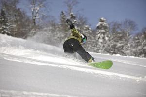 Snowboarder femme profiter du freeride sur la poudreuse fraîche photo