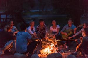 jeunes amis se détendant autour d'un feu de camp photo