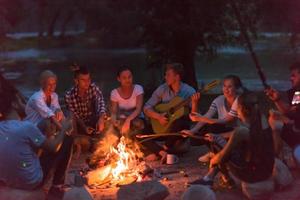 jeunes amis se détendant autour d'un feu de camp photo