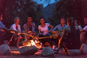 jeunes amis se détendant autour d'un feu de camp photo