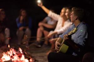 jeunes amis se détendant autour d'un feu de camp photo