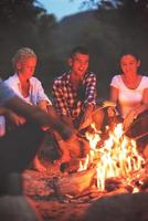 jeunes amis se détendant autour d'un feu de camp photo