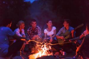 jeunes amis se détendant autour d'un feu de camp photo