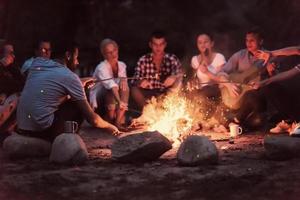 jeunes amis se détendant autour d'un feu de camp photo