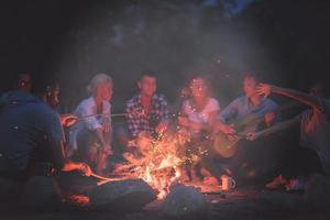 jeunes amis se détendant autour d'un feu de camp photo