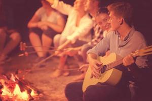 jeunes amis se détendant autour d'un feu de camp photo