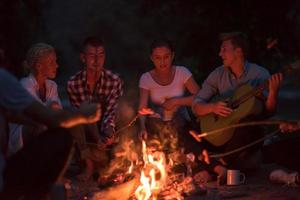 jeunes amis se détendant autour d'un feu de camp photo