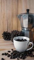 grains de café dans une tasse blanche sur une table en bois pour le contenu des aliments et des boissons. photo