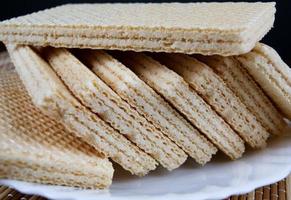 une pile de gaufres croustillantes se trouve sur une assiette blanche. photo