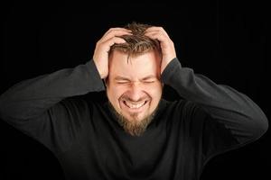 surmenage, concept de douleur à la tête. jeune homme en pull col polo noir. photo