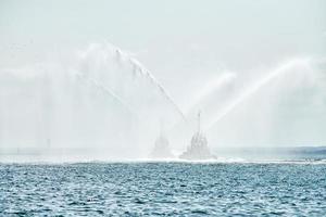 remorqueurs pulvérisant des jets d'eau, démontrant des canons à eau de lutte contre les incendies, pompiers pulvérisant de la mousse photo