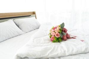 bouquet de mariage sur le lit dans la chambre, concept de lune de miel photo