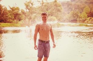 homme avec un torse nu éclaboussant de l'eau photo