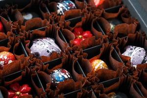 bonbons colorés de différentes formes faits à la main à partir de chocolat dans une boîte photo