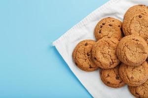 un tas de biscuits à l'avoine avec du chocolat sur une serviette sur fond bleu photo