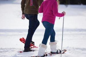 couple s'amusant et marchant en raquettes photo