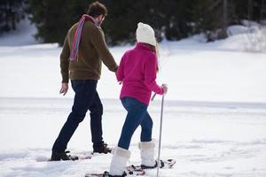 couple s'amusant et marchant en raquettes photo