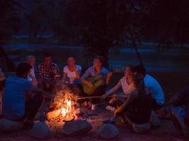 jeunes amis se détendant autour d'un feu de camp photo