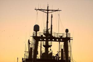 silhouettes de navires et de grues à conteneurs dans le port maritime photo