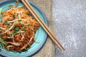 thai food pad thai thai nouilles sautées plat national servi dans une assiette bleue. photo