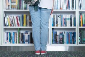 étudiante célèbre en sélectionnant un livre à lire dans la bibliothèque photo