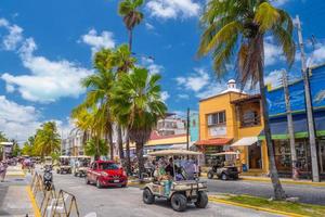 isla mujeres, mexique - avril 2022 voitures de golf dans la rue parmi les palmiers près de cancun photo