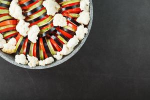 plat de ratatouille de légumes frais dans une poêle à frire sur fond sombre. photo