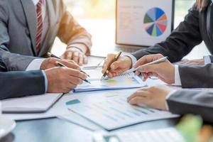 groupe de gens d'affaires professionnels travaillant ensemble pour analyser au bureau, travailler ensemble pour discuter du rapport de statistiques financières de l'entreprise, réfléchir à des idées et tracer des documents de référence sur la table. photo