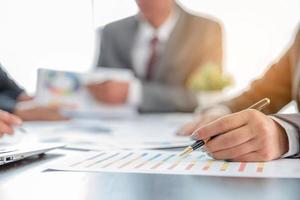 groupe de gens d'affaires professionnels travaillant ensemble pour analyser au bureau, travailler ensemble pour discuter du rapport de statistiques financières de l'entreprise, réfléchir à des idées et tracer des documents de référence sur la table. photo