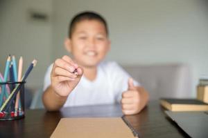 jeune étudiant apprentissage à distance cours virtuel à distance en ligne sur appel vidéo leçon virtuelle, technologie étudiant à la maison à l'aide d'un ordinateur portable. parent ou tuteur enseignant à un enfant garçon avec une éducation à distance. photo