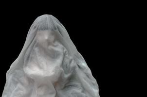 couverture de poupée de longs cheveux noirs avec drap blanc se noyer dans l'eau sur fond sombre. concept effrayant minimal d'halloween. photo
