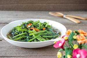 Épinards d'eau sautés ou pak boong fai daeng sur plat blanc photo