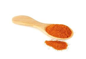 Paprika rouge moulu en poudre ou piment sec avec cuillère en bois isolé sur fond blanc photo