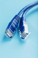 deux connecteurs de câble ethernet cordon de raccordement cordon gros plan isolé sur un fond bleu avec de l'espace libre photo