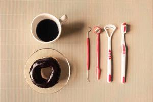 vue de dessus de la tasse à café avec beignet et équipement d'outils dentaires sur la table. photo