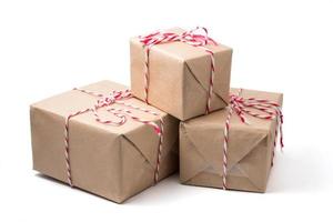 paquets cadeaux enveloppés dans du papier brun sur fond blanc. photo