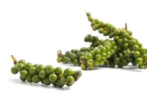 grains de poivre vert sur fond blanc. photo