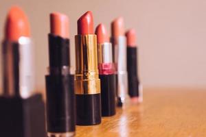 rouges à lèvres colorés sur la table en bois. concept de maquillage et de beauté. mise au point sélective photo