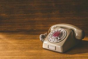 vieux téléphone sur fond de table en bois. photo